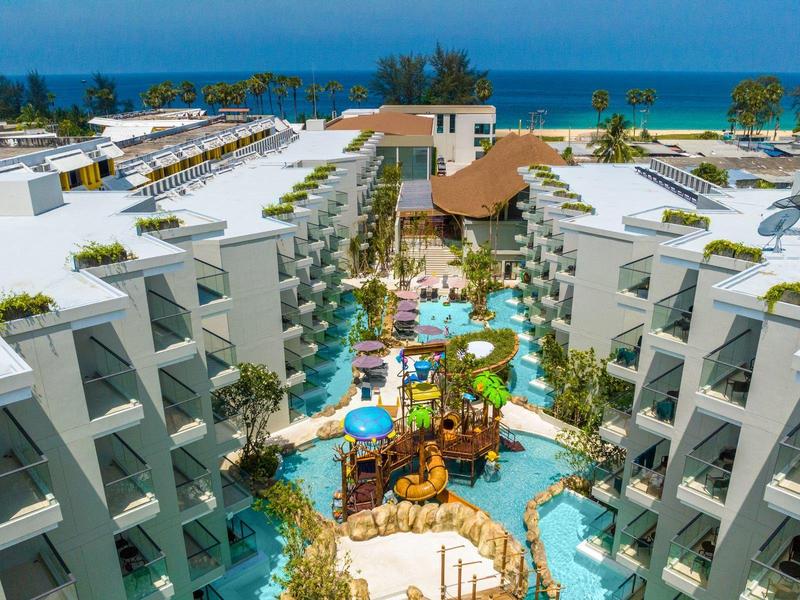 Hotelanlage mit Pools, Liegen und direktem Zugang zum Strand und Meer im Hintergrund