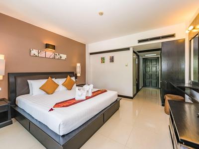 Modernes Hotelzimmer mit großem Doppelbett, Sitzbereich und minimalistischem Design.