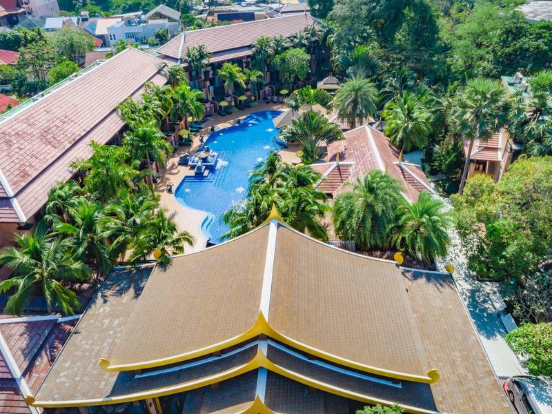 Vogelperspektive auf ein Resort mit Pool und üppiger Vegetation.