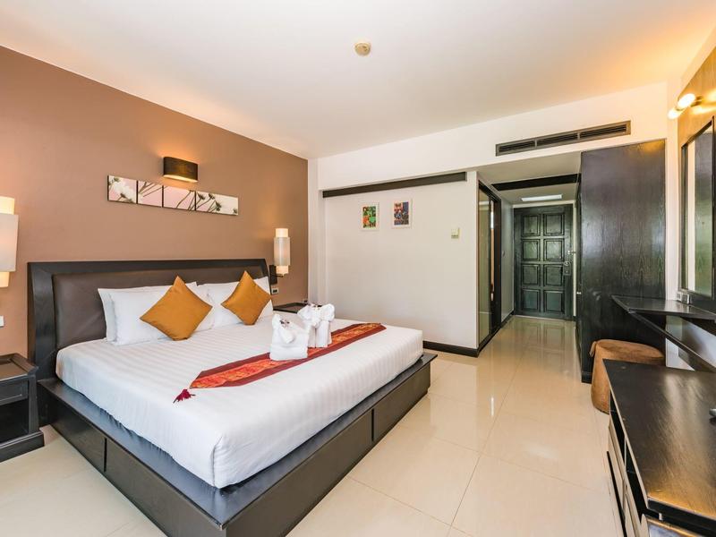 Modernes Hotelzimmer mit großem Doppelbett, Sitzbereich und minimalistischem Design.