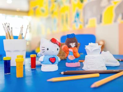 Kolorowy zestaw do malowania i rękodzieła z figurką Hello Kitty na niebieskim stole w kreatywnym pokoju