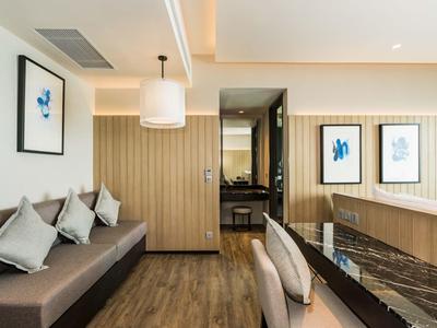 Modern ingerichte woonkamer met bank, kussens, eettafel en uitzicht op keuken.