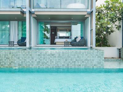 Moderner Außenbereich mit Pool vor einer Hotelterrasse mit Möbeln.