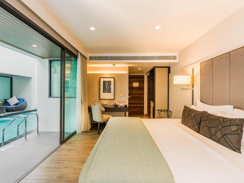 Modern hotelkamer met groot bed en toegang tot het zwembad.