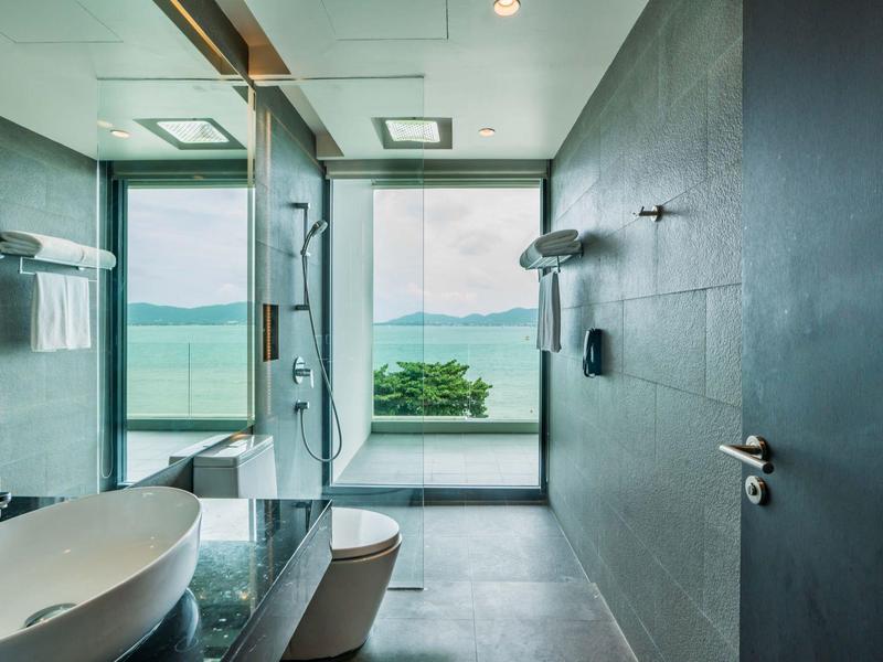 Moderne badkamer met groot raam met uitzicht op meer en bergen.