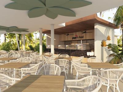 Buitengebied van de bar met witte tafels en stoelen onder een overdekt paviljoen.