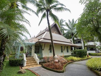 Ein tropisches Resort mit einem weißen Haus, umgeben von Palmen und üppigem Grün.