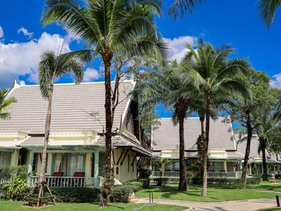 Hotel buildings with palm trees and blue sky in tropical resort
