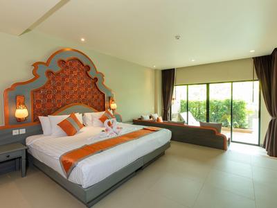 Camera d'hotel moderna con letto grande, panca accogliente e finestre dal pavimento al soffitto con vista sul verde.