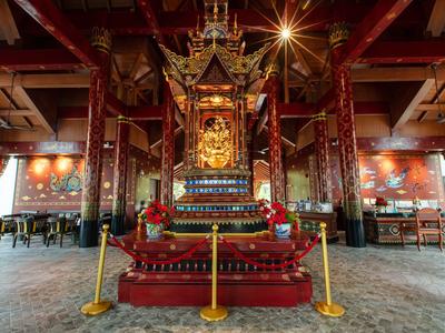 Magnifico trono dorato in un interno tradizionale asiatico riccamente decorato.