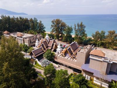Vista di un resort con architettura tradizionale e il mare sullo sfondo sotto un cielo azzurro.