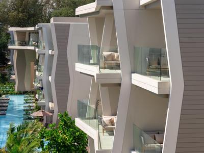 Edifici hotel moderni con balconi e una lunga piscina tra gli edifici.