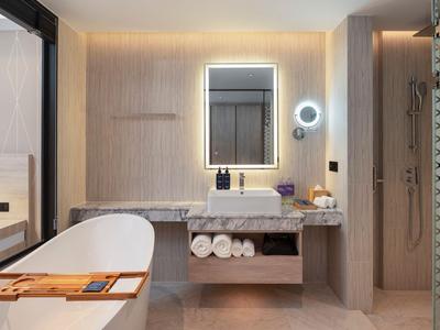 Bagno moderno in hotel con vasca da bagno indipendente e specchio illuminato.