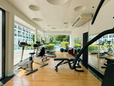 Moderner Fitnessraum mit Trainingsgeräten und Holzfußboden in hellem, offenem Raum.