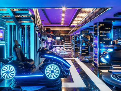 Modern entertainment room with gaming chairs and glowing neon lights.