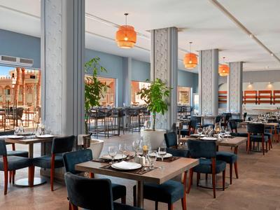 Elegantní moderní restaurace s prostřenými stoly a velkými okny.