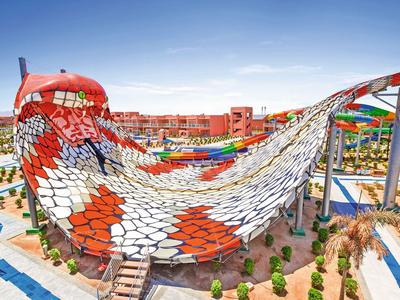 Große Wasserrutsche in Form einer Schlange in einem Freizeitpark bei klarem Himmel.