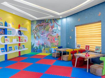 Bunter Kinderspielraum mit buntem Boden, Regalen und Sitzgelegenheiten in fröhlichem Design.
