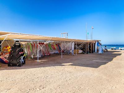 Strandverleih mit bunten Surfbrettern und klar blauem Himmel am Meer