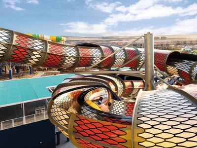 Toboganes de agua tubulares coloridos con vista del área circundante y el cielo.