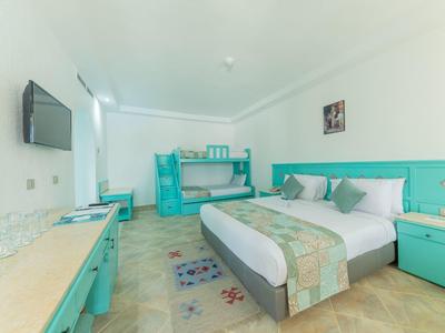 Bright hotel room with double bed, bunk bed, and turquoise furniture