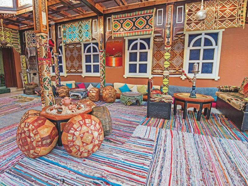 Colorful courtyard with traditional cushions, rugs, and painted wooden windows