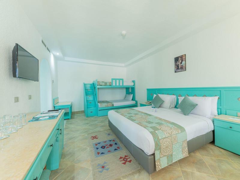 Bright hotel room with double bed, bunk bed, and turquoise furniture