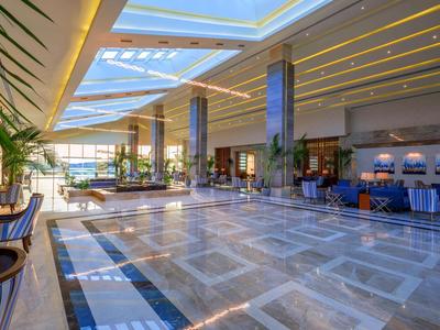 Ruime, lichte hotel lobby met comfortabele zitplaatsen en glazen dak.