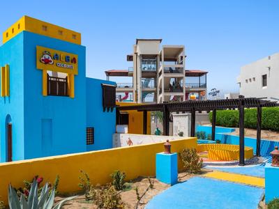 Colorful outdoor area with blue tower, pool, and modern architecture under clear sky.