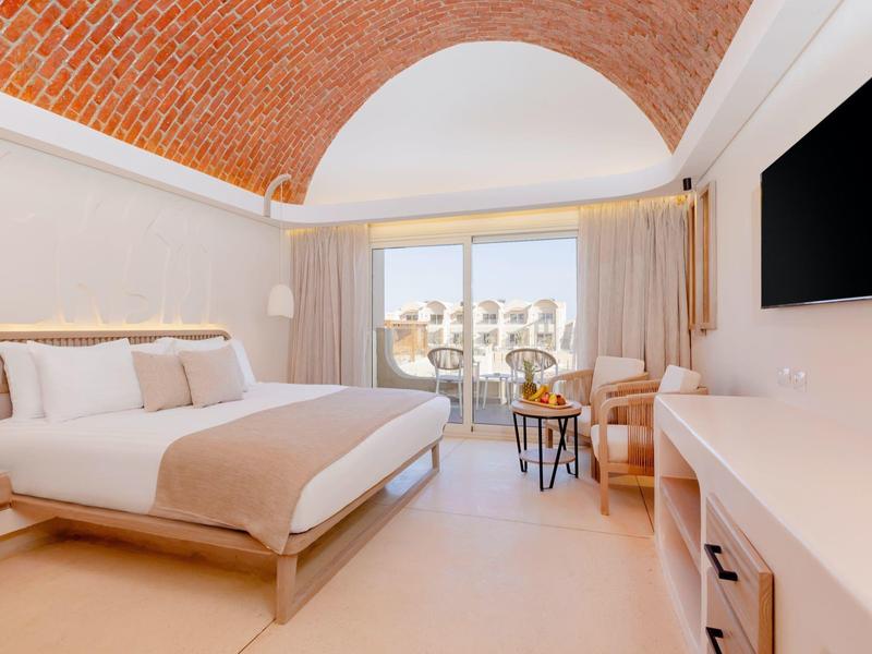 Helles, modernes Schlafzimmer mit gewölbter Decke und Panoramafenster mit Balkonblick.