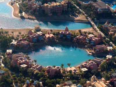 Aerial view of a resort with a large lagoon surrounded by buildings and lush greenery.