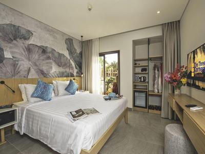 Habitación de hotel moderna con cama doble, gran ventana y televisor en la pared.