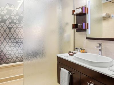 Modern bathroom with vanity, round sink, and frosted glass sliding door.