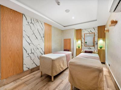 Salle de bien-être moderne avec deux tables de massage et éclairage doux