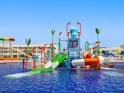 Buntes Wasserspielgerät mit Rutschen in einem Pool unter blauem Himmel.
