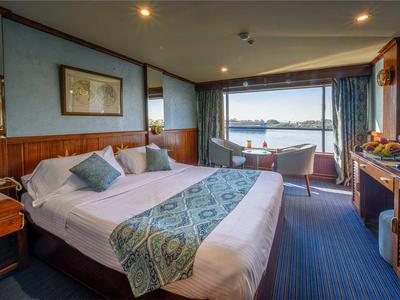 Camera d'albergo accogliente con letto matrimoniale e grande finestra con vista lago