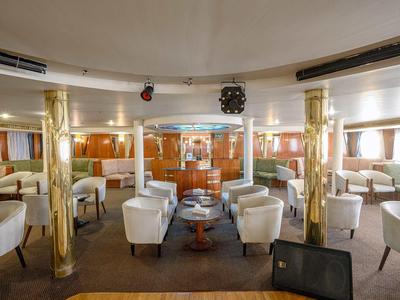 Intérieur d'un bateau de luxe avec des fauteuils blancs et des colonnes dorées