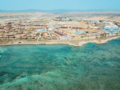 Aerial view of a coastal resort with clear blue water and sandy beaches under a bright sky.