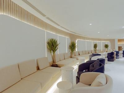 Moderner Hotel-Loungebereich mit bequemen Sofas, Pflanzen und sanfter Beleuchtung.