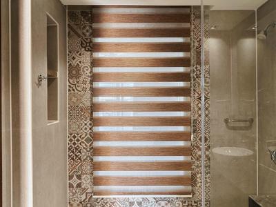 Baño moderno con ducha de vidrio y azulejos decorativos en la pared.