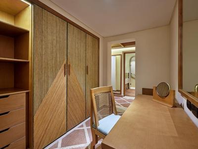 Kompakter Raum mit Schrank, Schreibtisch, Holzstuhl und spiegelndem Kosmetikspiegel.