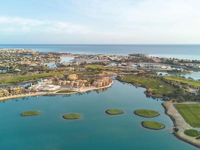 Luchtfoto van een kustplaats met blauw water, kleine eilanden en woongebieden