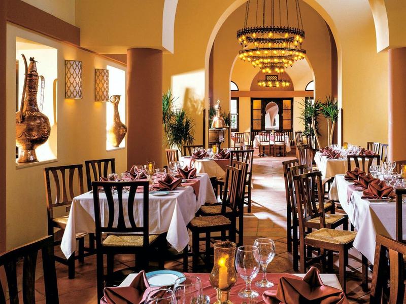 Elegancka sala restauracyjna z nakrytymi stołami i ciepłym oświetleniem.