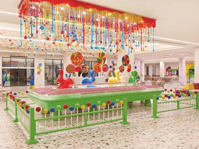 Bunter, moderner Kinderspielbereich mit Karussell und verzierten Deckenbeleuchtungen in hellem Raum.