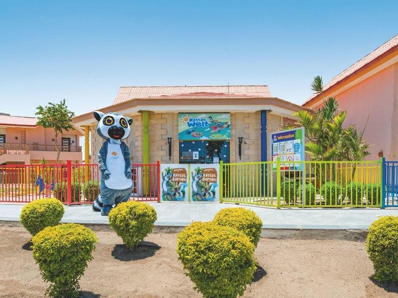 Buntes Gebäude mit großem Erdmännchen vor einem Hotel oder Resort