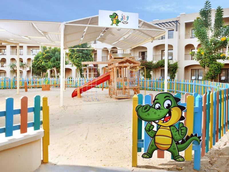 Area giochi colorata per bambini con scivoli e recinzione decorata in un hotel.