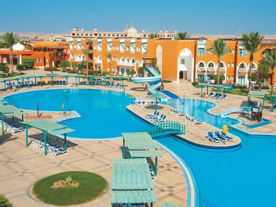 Gran piscina al aire libre frente a un edificio de hotel con sombrillas y tumbonas