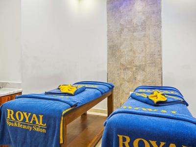 Two blue massage beds with yellow logo text in a wellness room.