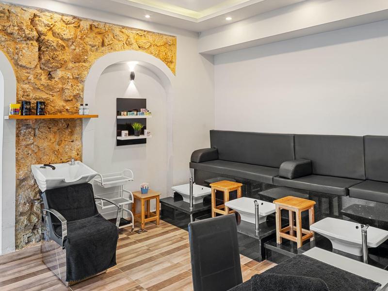 Modern waiting area with black seating and rustic stone wall.