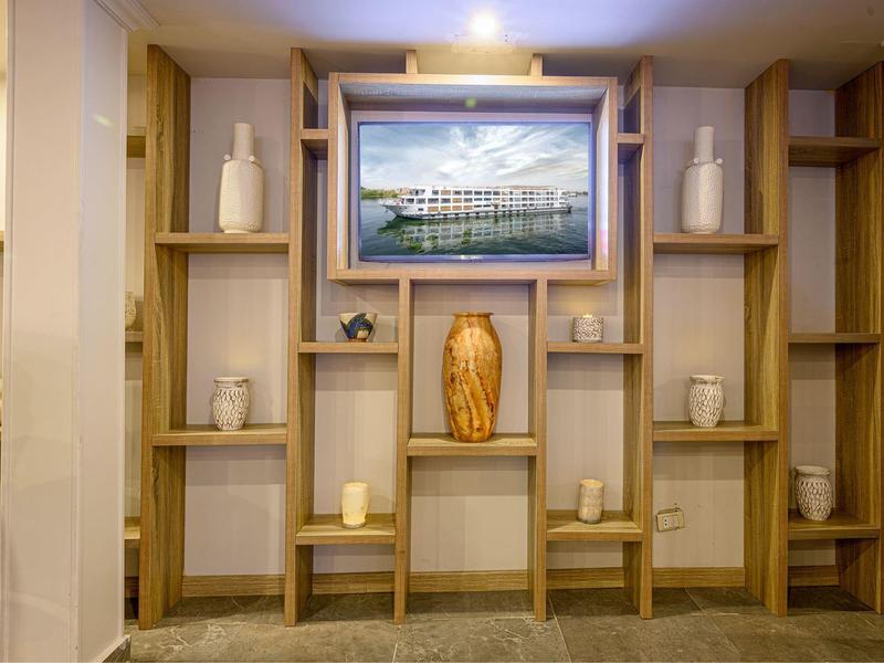 Un mur avec étagères en bois, décoré de vases et une grande photo d'un bâtiment.